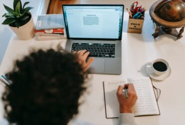 unrecognizable author typing on laptop near coffee at home author typing on laptop near coffee at home